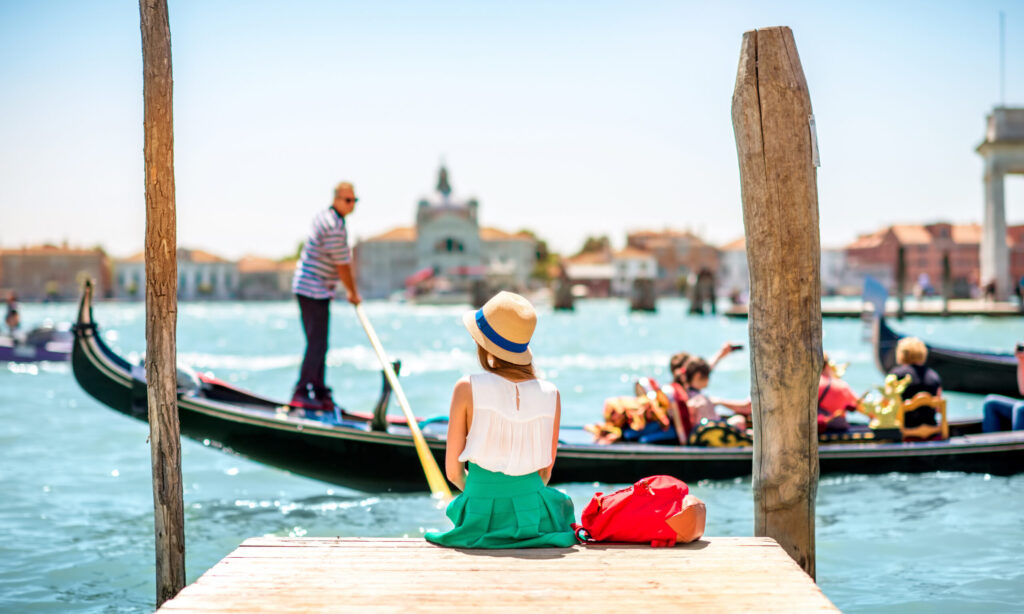 Woman looking at typical Venetian Gondolas on Grand Canal