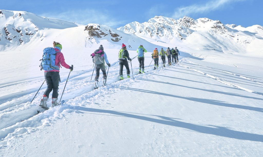 Group of touring skiers whit alpine guide reaching their goal