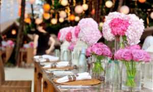 Hochzeitstisch mit pinken und rosa Blumen.