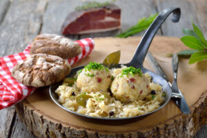 Delicious South Tyrolean bacon dumplings served on sauerkraut in an iron frying pan