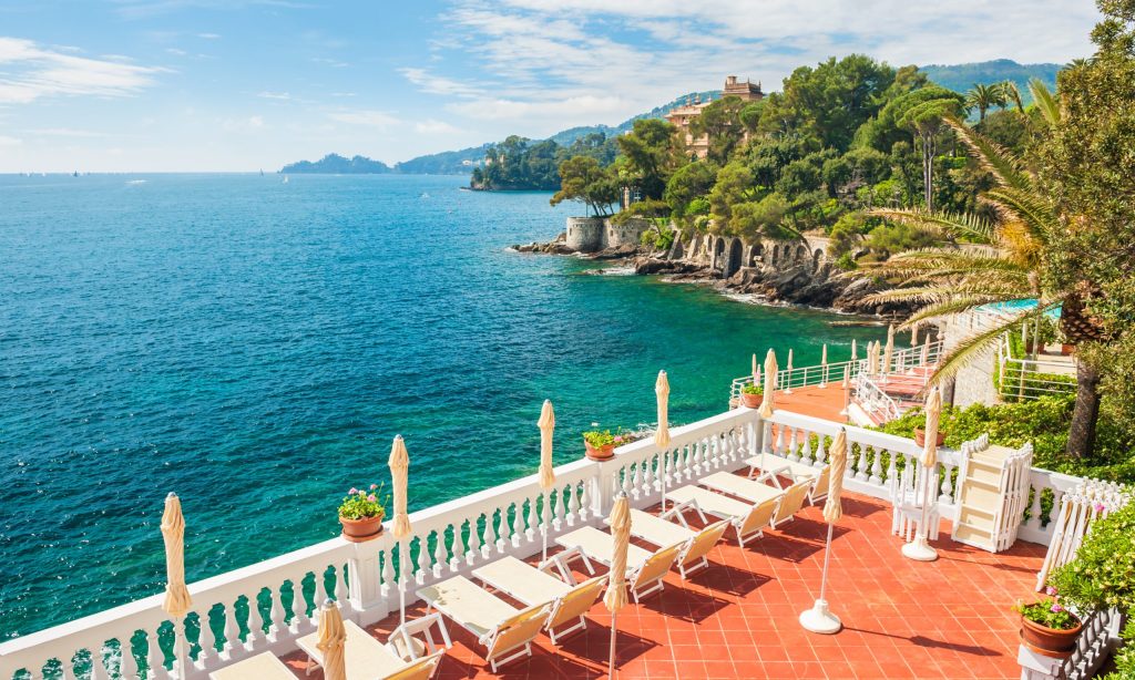 Terrace with deck chairs overlooking the sea. Beautiful summer landscape in Ligurian coast, Italy