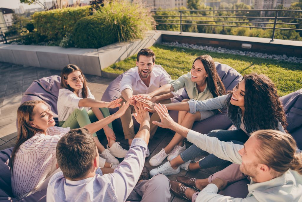 Photo of entrepreneurs sitting beanbags support cooperation training outdoors outside workshop workstation urban city terrace.
