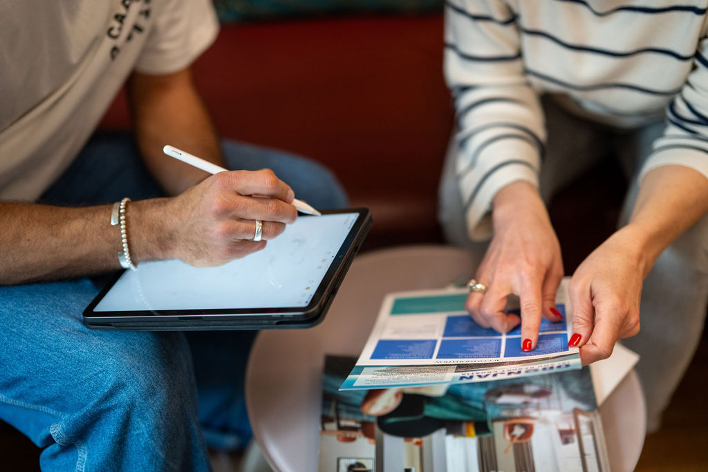 two people planning an en event with iPad and brochure in their hands.