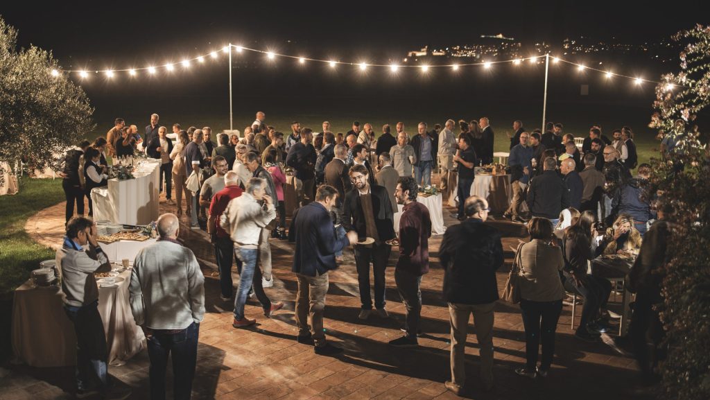 Gruppe von Menschen bei einem Treffen, Aperitif im Freien bei Nacht, Lichter.