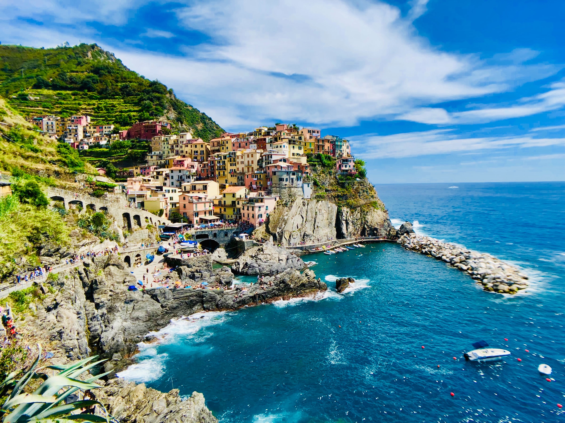 Bay in Liguria with colorful houses and boats on the water.