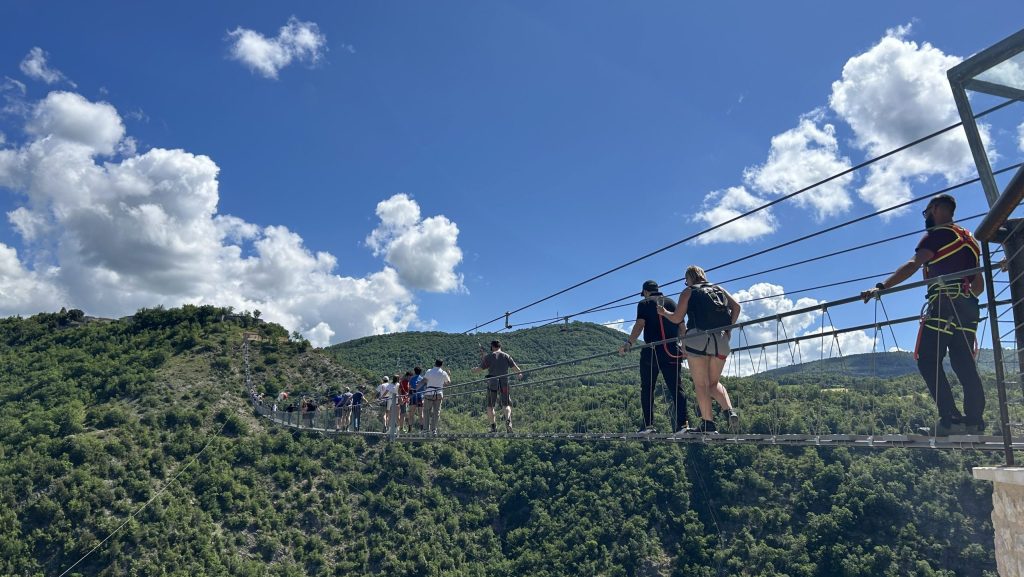 Gruppe von Leuten auf Hängebrücke.