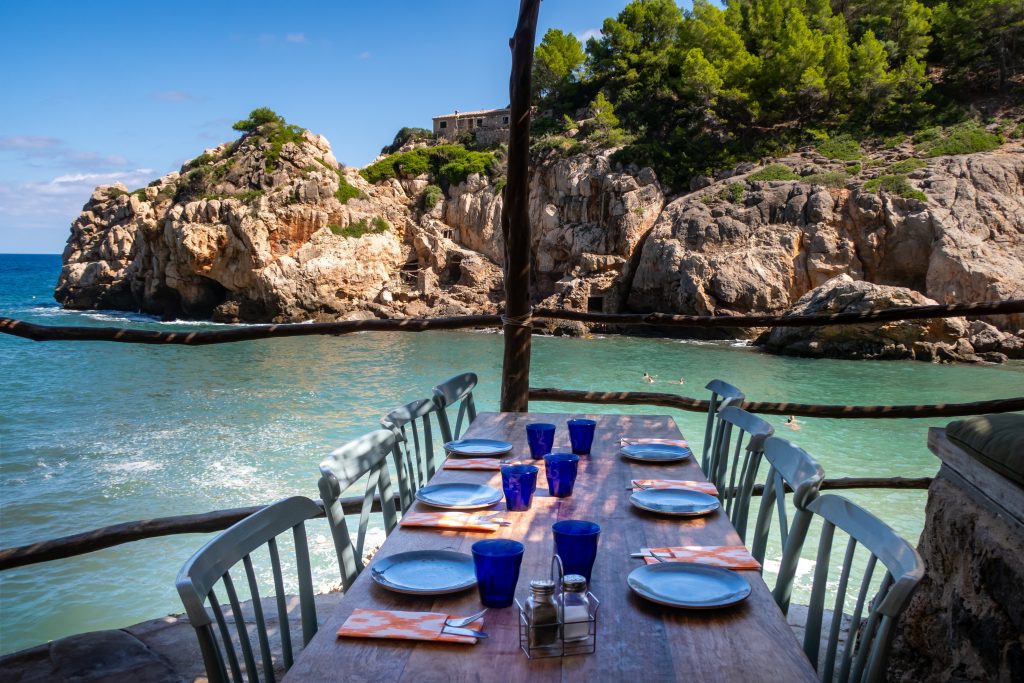 Restaurant with tables and chairs, ocean view.