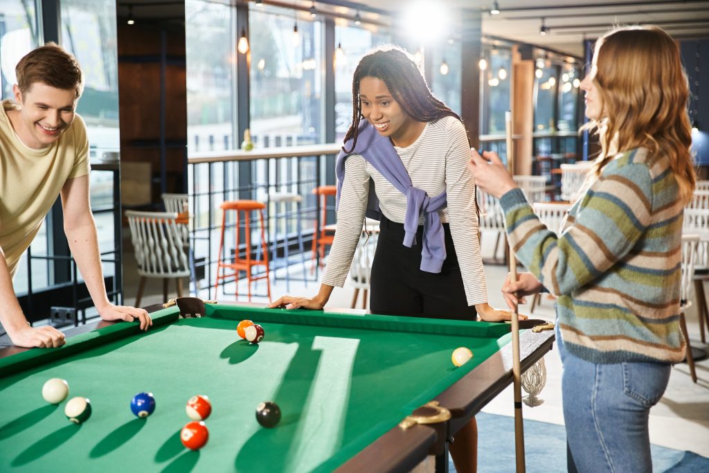 3 people playing billard at a co-working space.