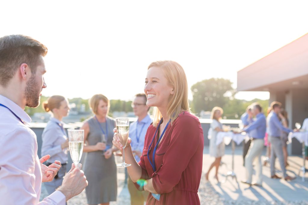 Young blonde business woman having a conversation with her colleague at a business meeting outdoors.