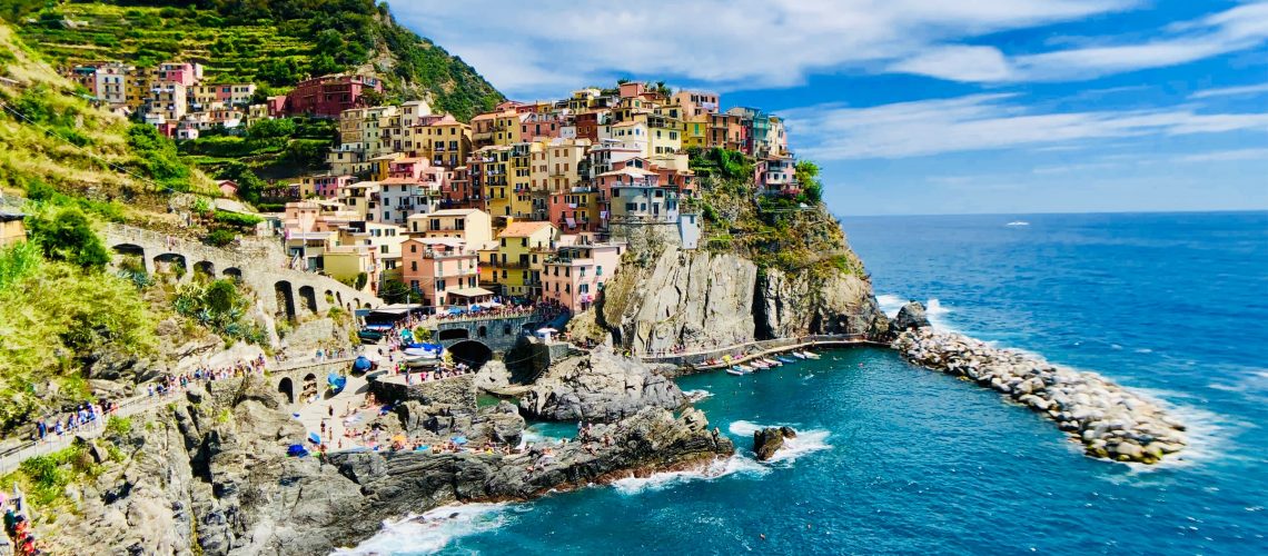Bay in Liguria with colorful houses and boats on the water.