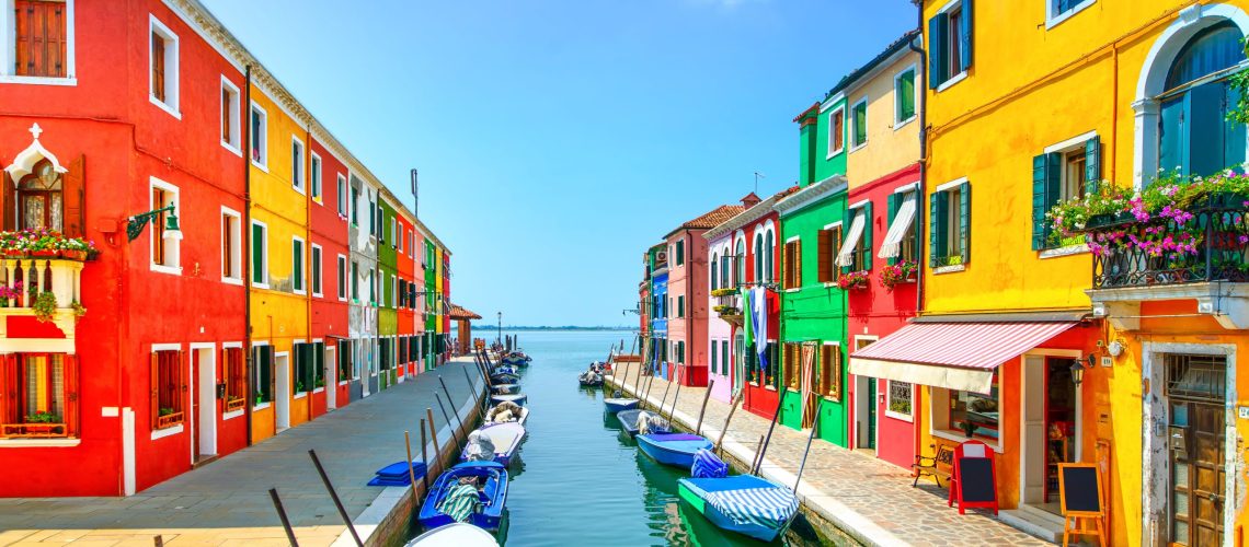 Venice landmark, Burano island canal, colorful houses and boats.