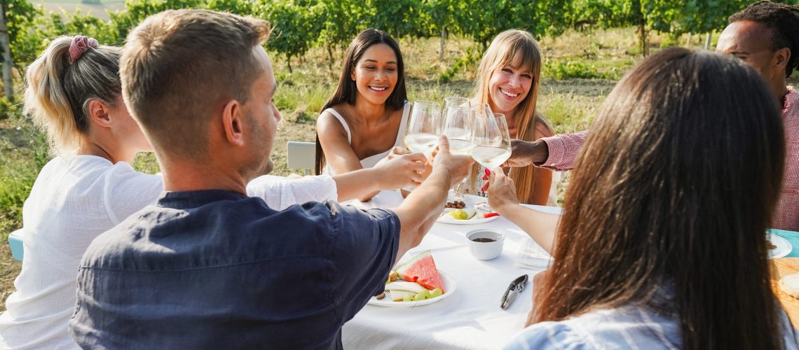 Friends are celebrating with wine and food, dinner outside in Tuscany.